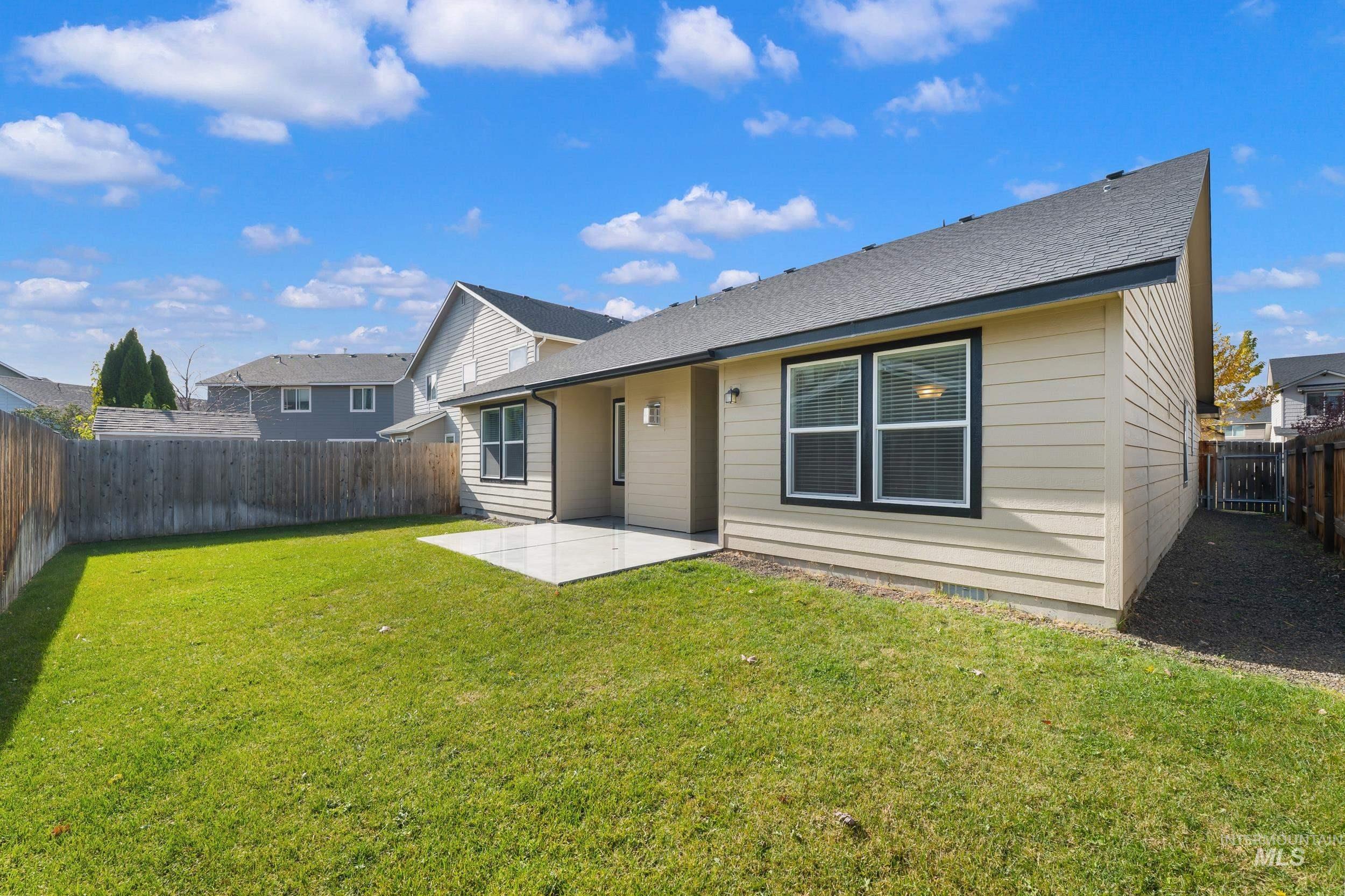 Rear view of property with a patio, a fenced backyard, and a shingled roof