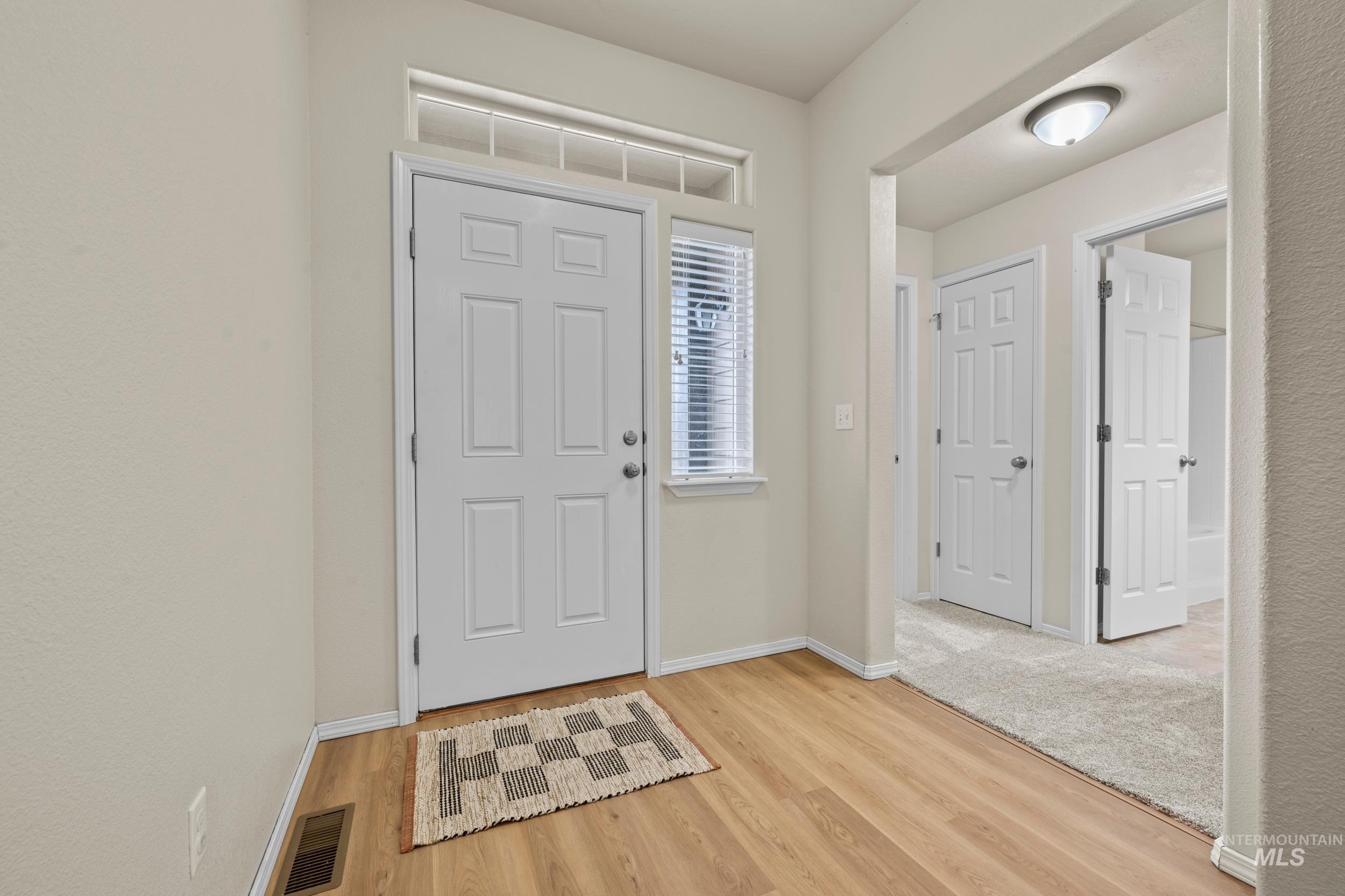 Entryway with light wood-type flooring and baseboards