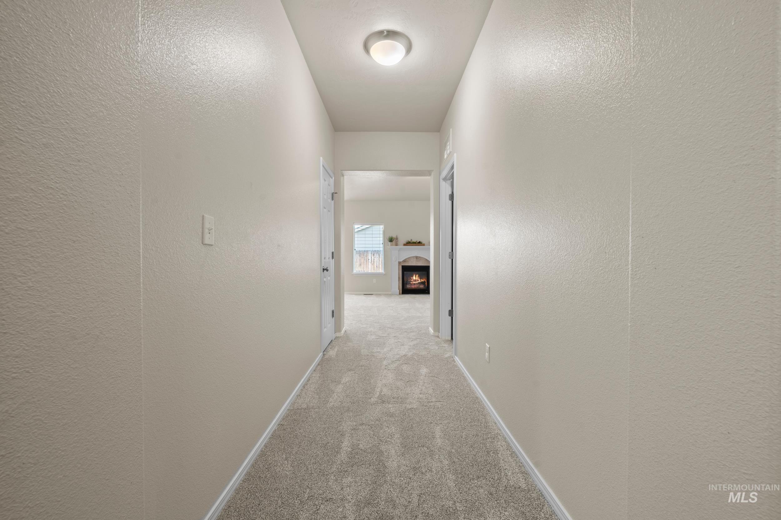Corridor with a textured wall and light carpet