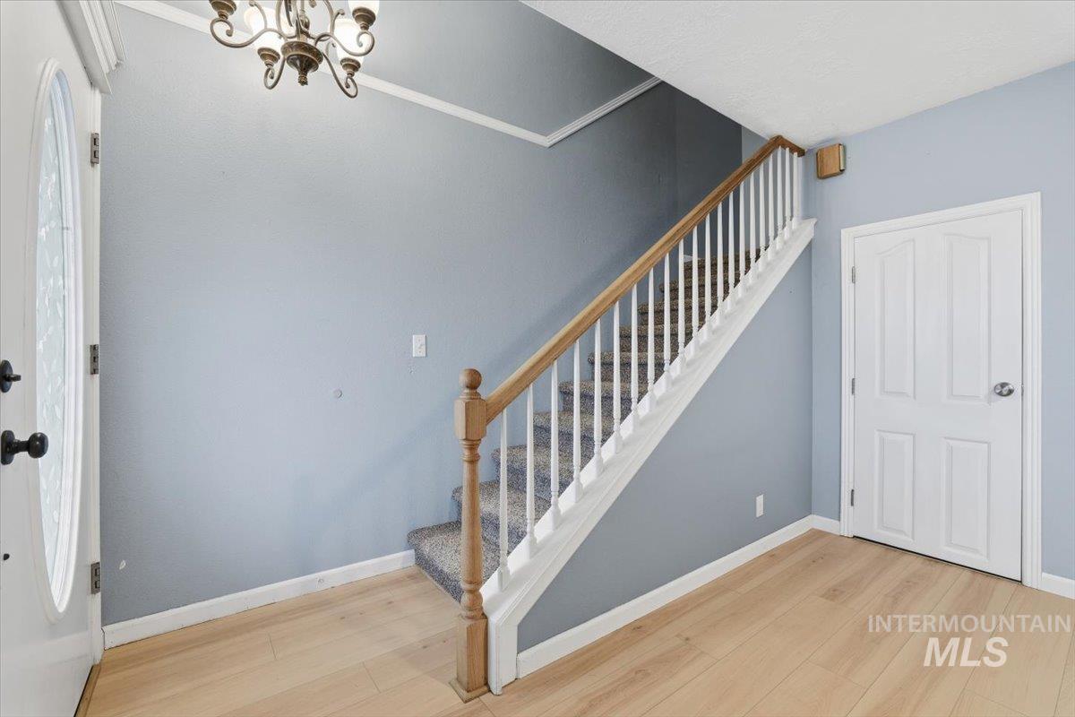 Staircase featuring wood finished floors and a chandelier