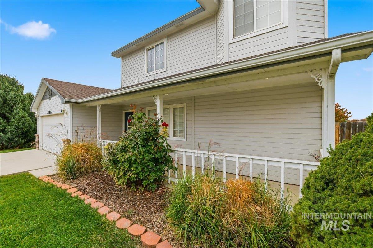 View of front of home with a porch, a garage, and driveway