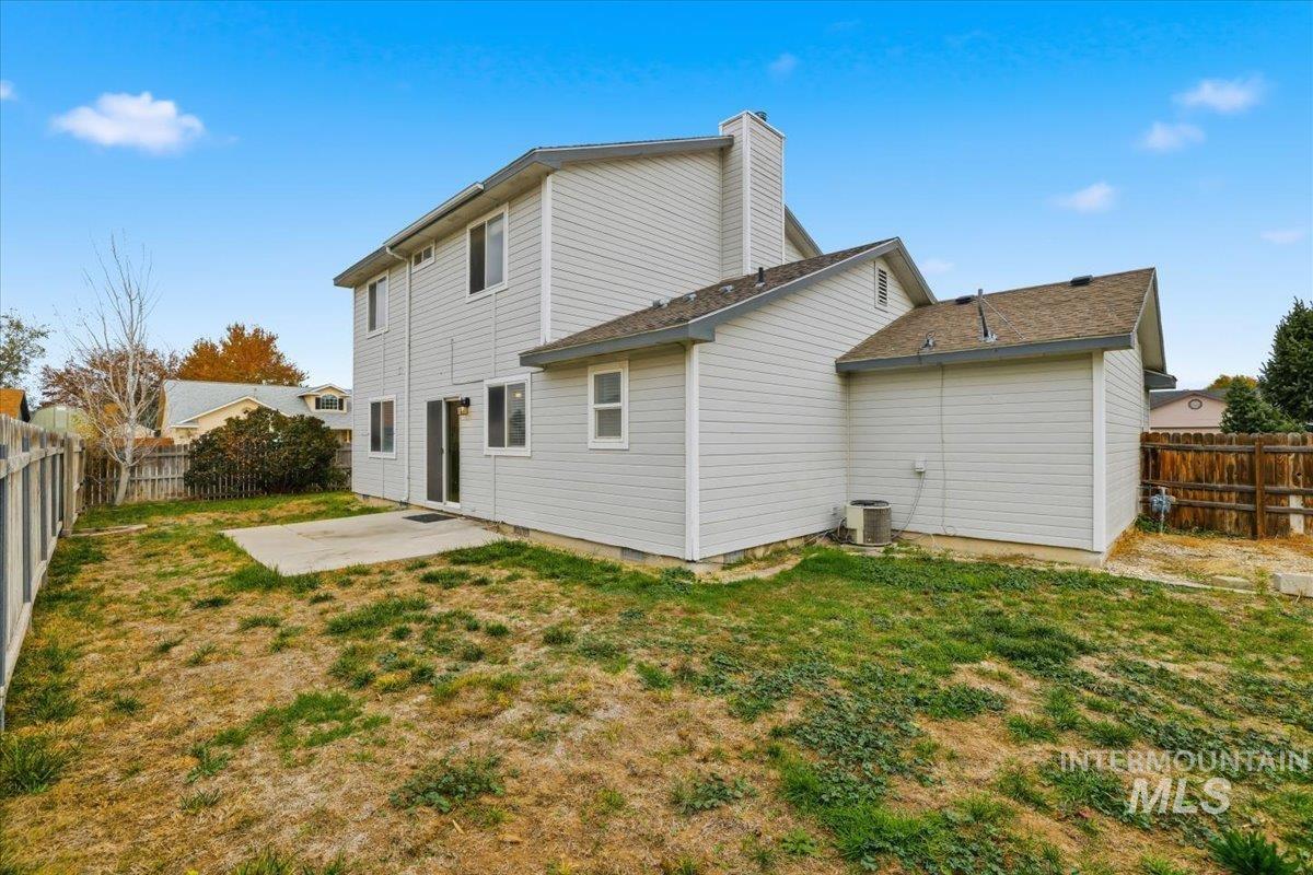Rear view of property featuring a patio, a fenced backyard, and a chimney