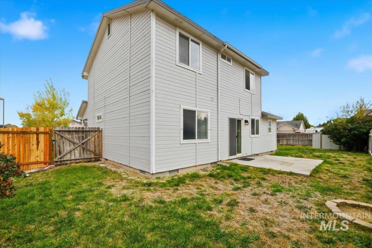 Back of property with a fenced backyard, a patio area, a gate, and crawl space