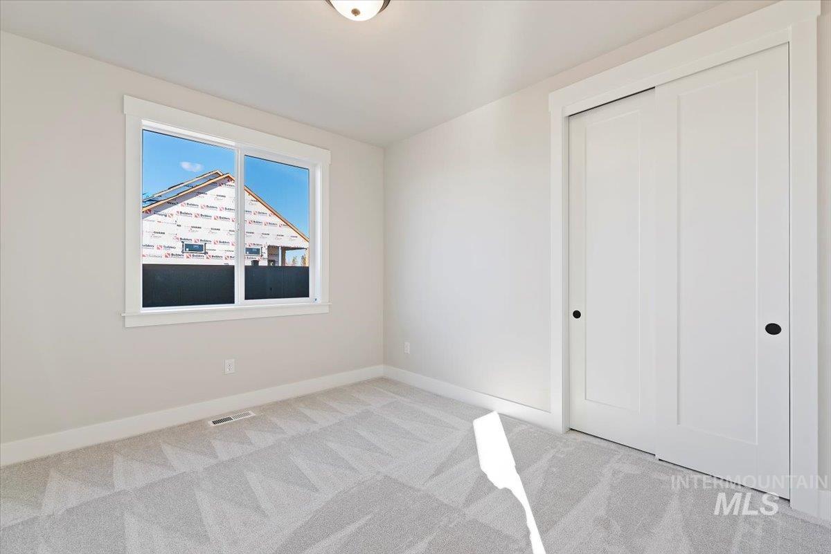 Unfurnished bedroom featuring light carpet and a closet