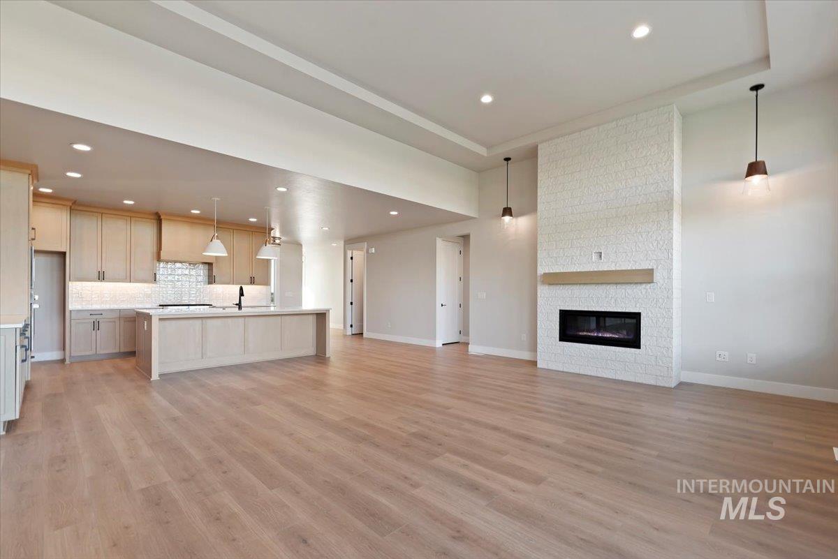 Unfurnished living room with light wood-style floors, recessed lighting, and a fireplace