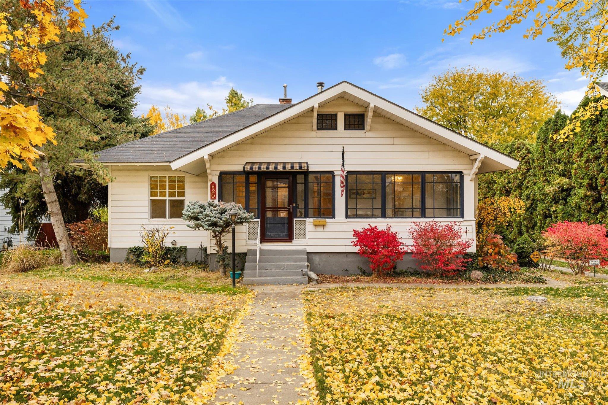 Bungalow-style home featuring a sunroom and a front lawn