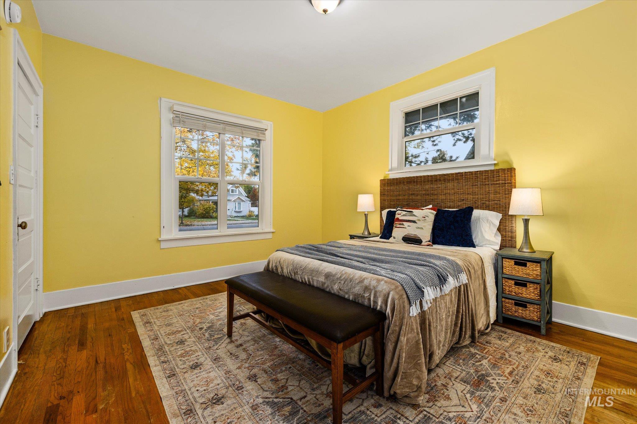 Bedroom with baseboards and dark wood-type flooring