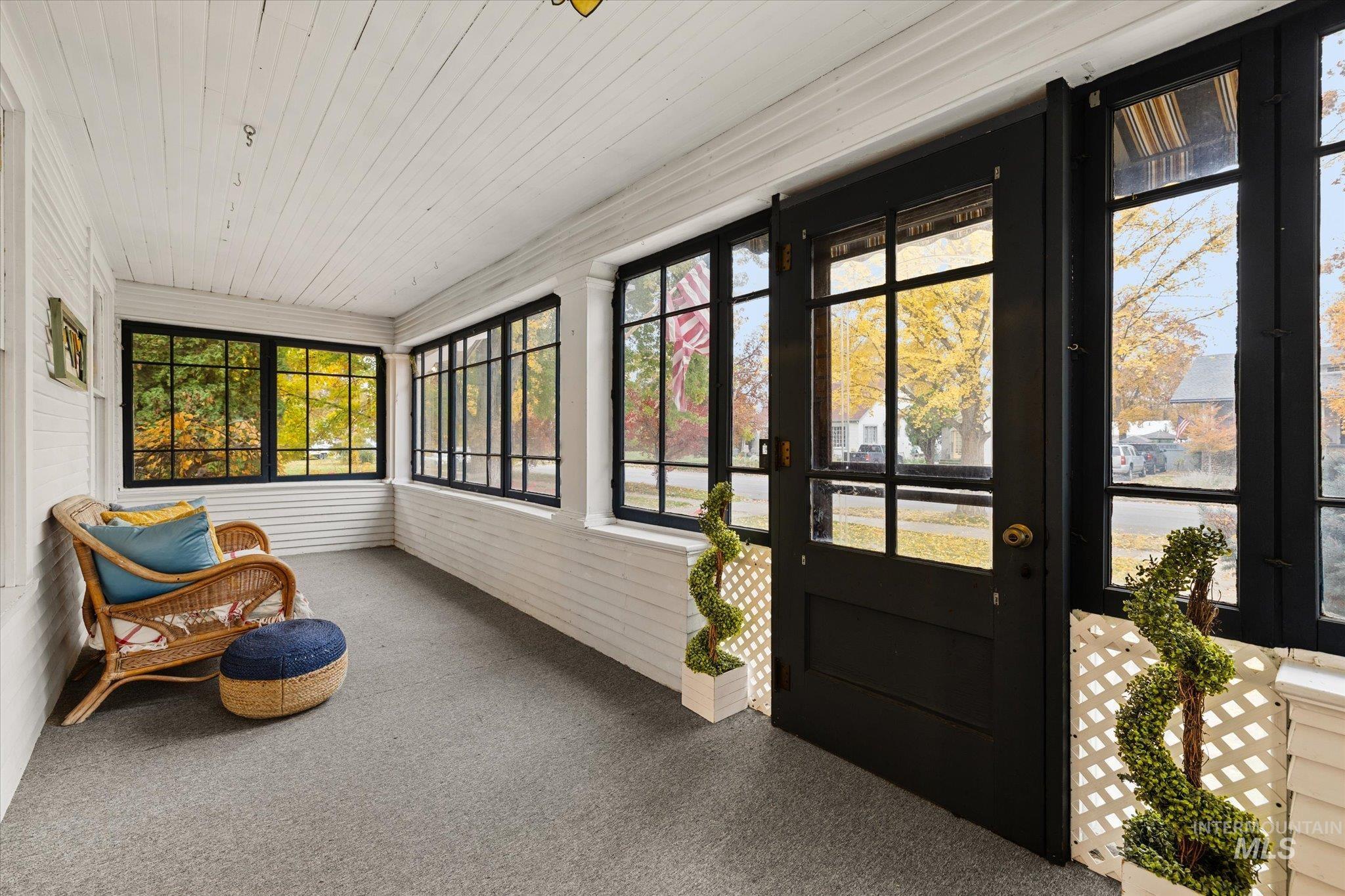 Sunroom / solarium featuring carpet flooring and wood ceiling