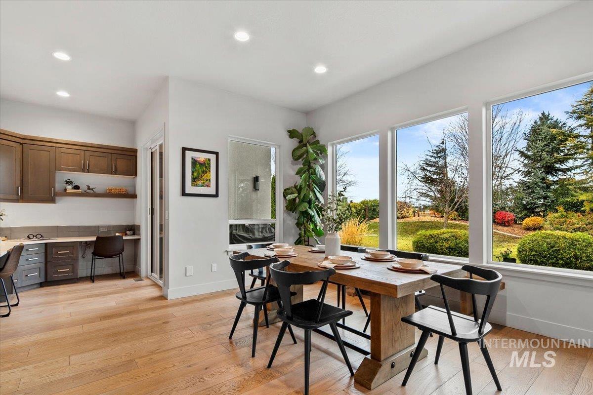 Dining space featuring built in desk, light wood-style floors, and recessed lighting