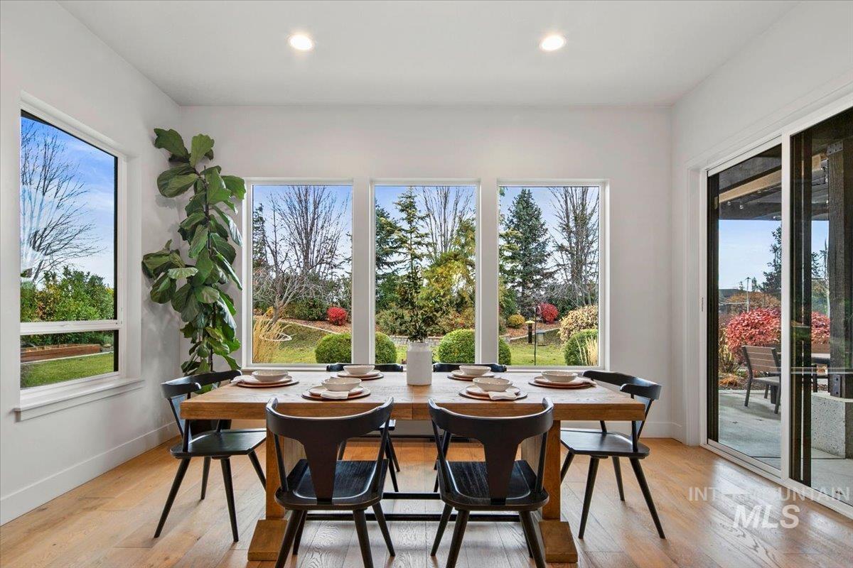 Dining room with light wood-style flooring and recessed lighting