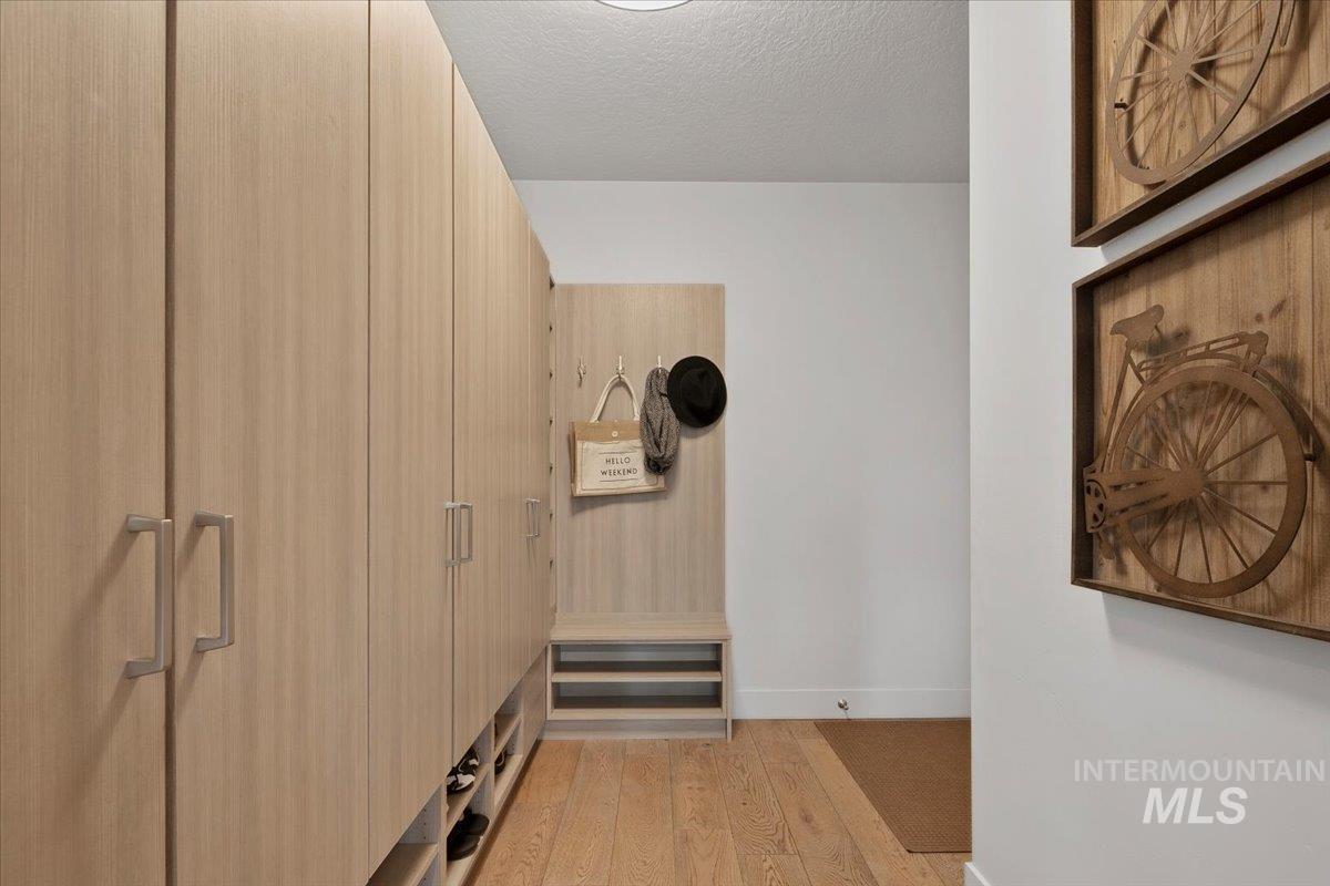 Corridor featuring light wood finished floors and a textured ceiling