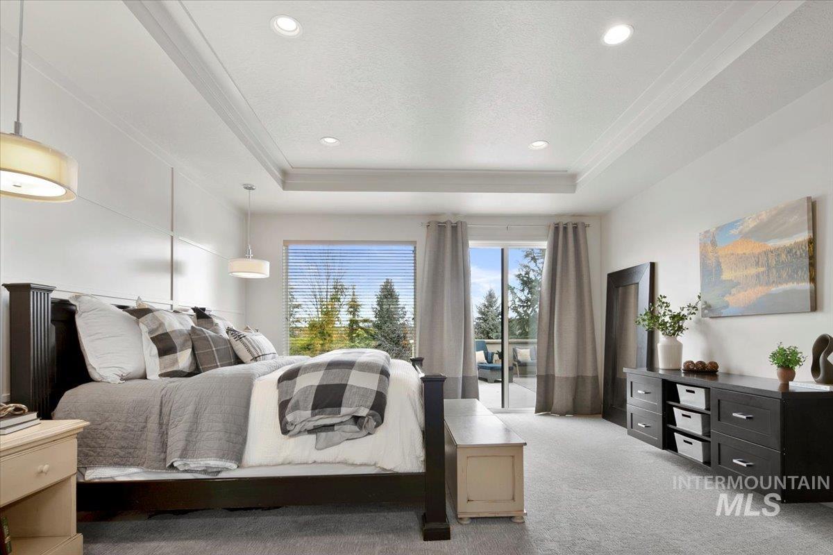 Bedroom with light carpet, a tray ceiling, recessed lighting, ornamental molding, and access to exterior
