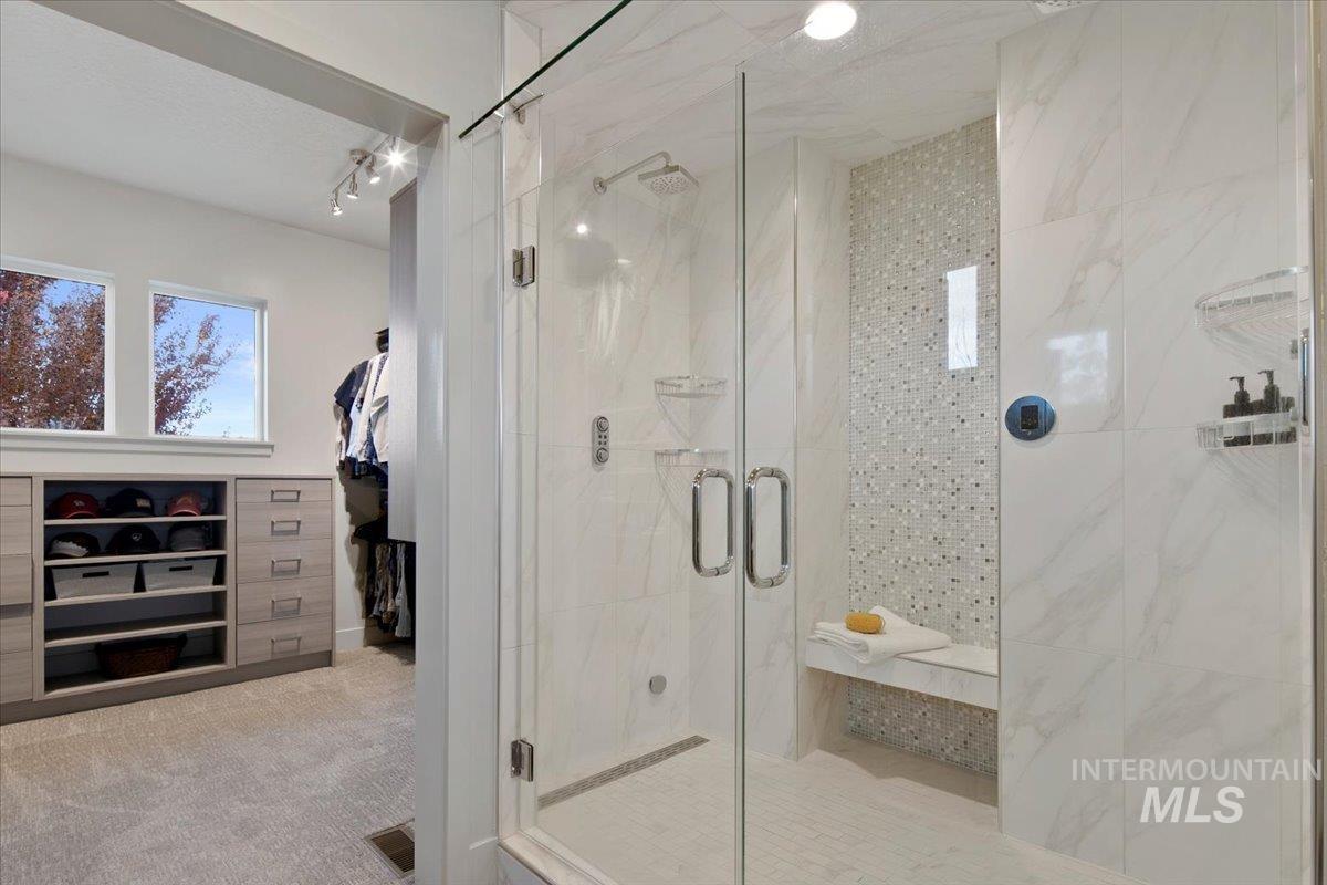 Bathroom featuring a shower stall and light carpet