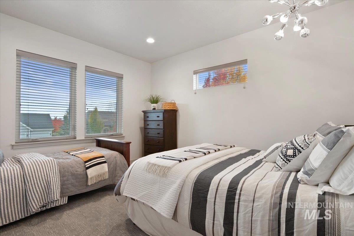 Bedroom featuring multiple windows, recessed lighting, and a chandelier