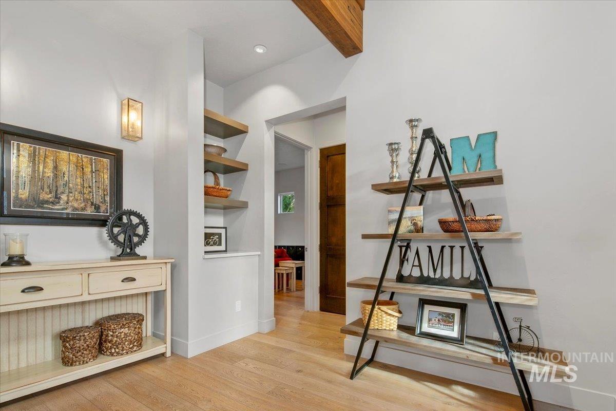 Corridor featuring beam ceiling and light wood-style flooring