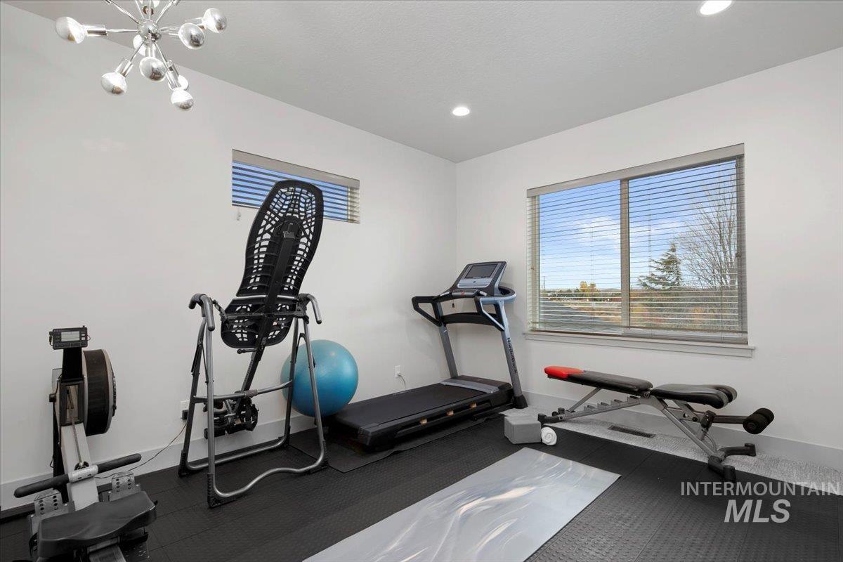 Workout area featuring a chandelier and recessed lighting