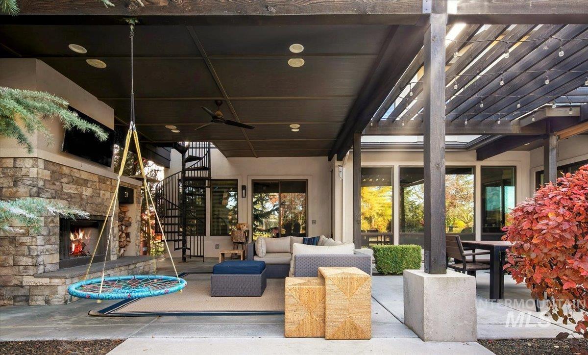 View of patio / terrace featuring an outdoor living space with a fireplace, ceiling fan, stairs, a pergola, and outdoor dining area