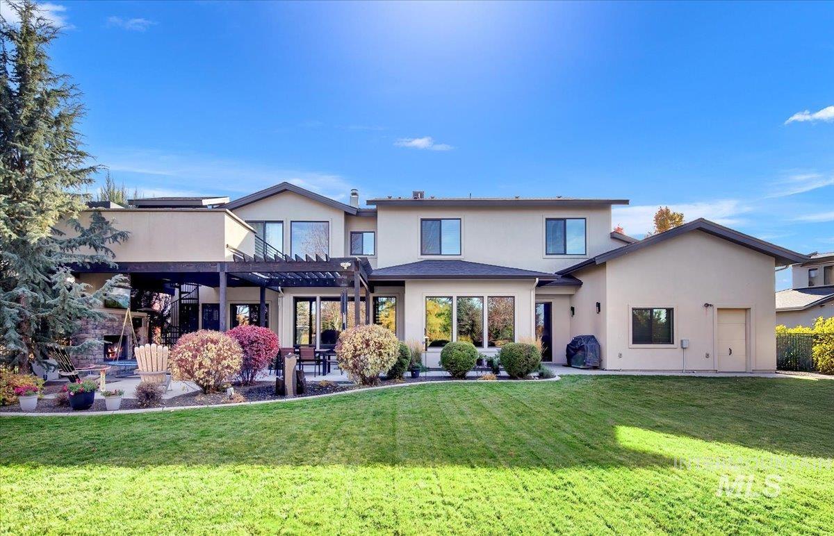 Rear view of house featuring a yard, stucco siding, a patio area, and a pergola