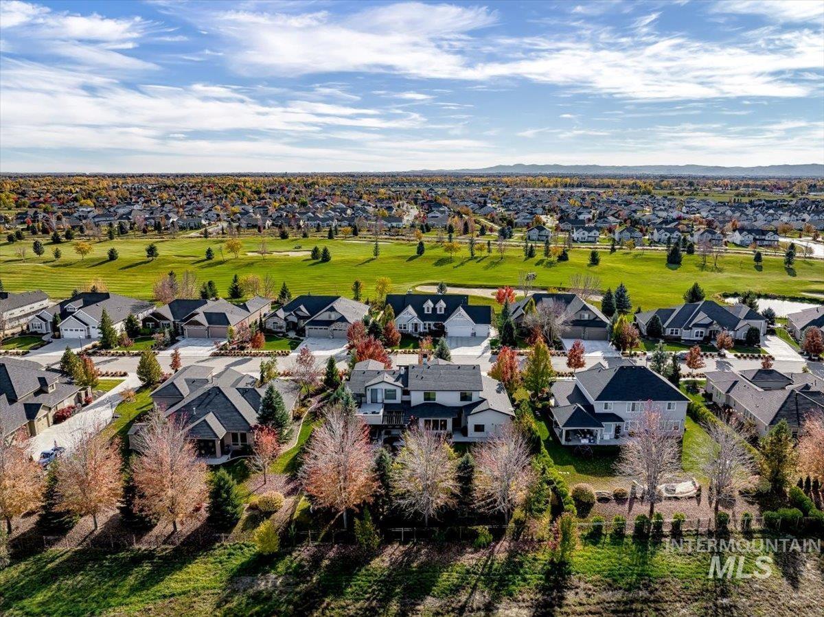 Aerial view of residential area with a golf club and a mountainous background