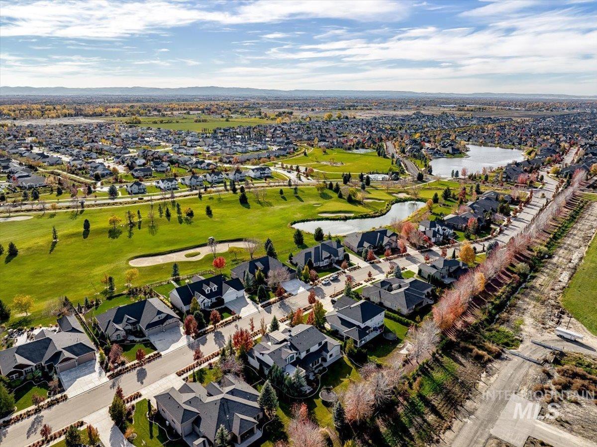 Aerial perspective of suburban area with a nearby body of water and a golf club