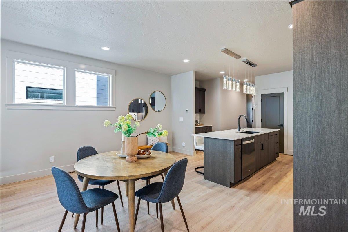 Dining room with light wood-style flooring, recessed lighting, and a textured ceiling