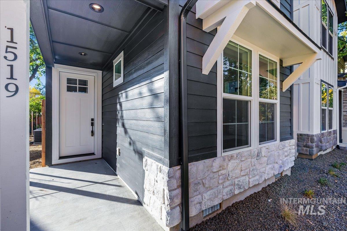 Doorway to property featuring stone siding, crawl space, and board and batten siding