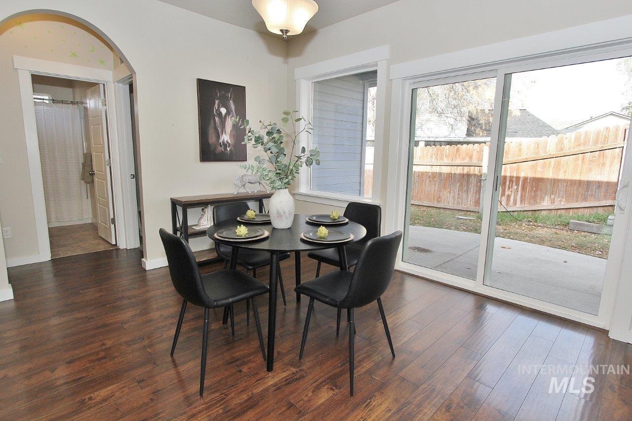 Dining space featuring dark wood-style floors and arched walkways