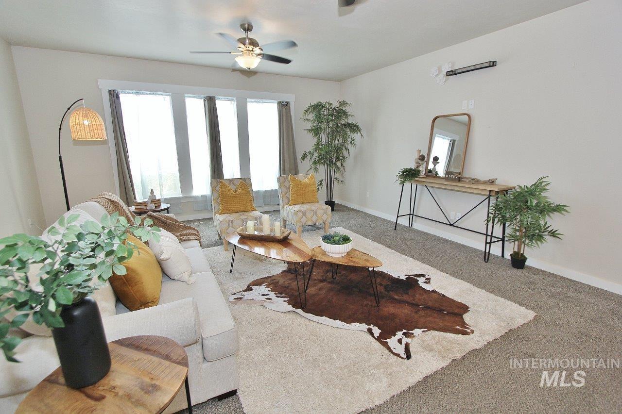 Living area featuring carpet and a ceiling fan