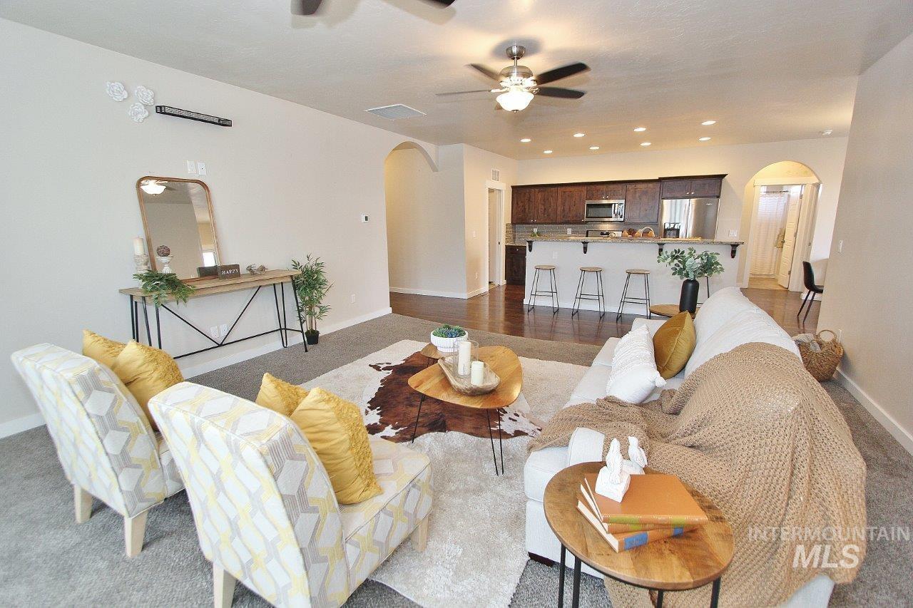 Living room with arched walkways, carpet, recessed lighting, and ceiling fan