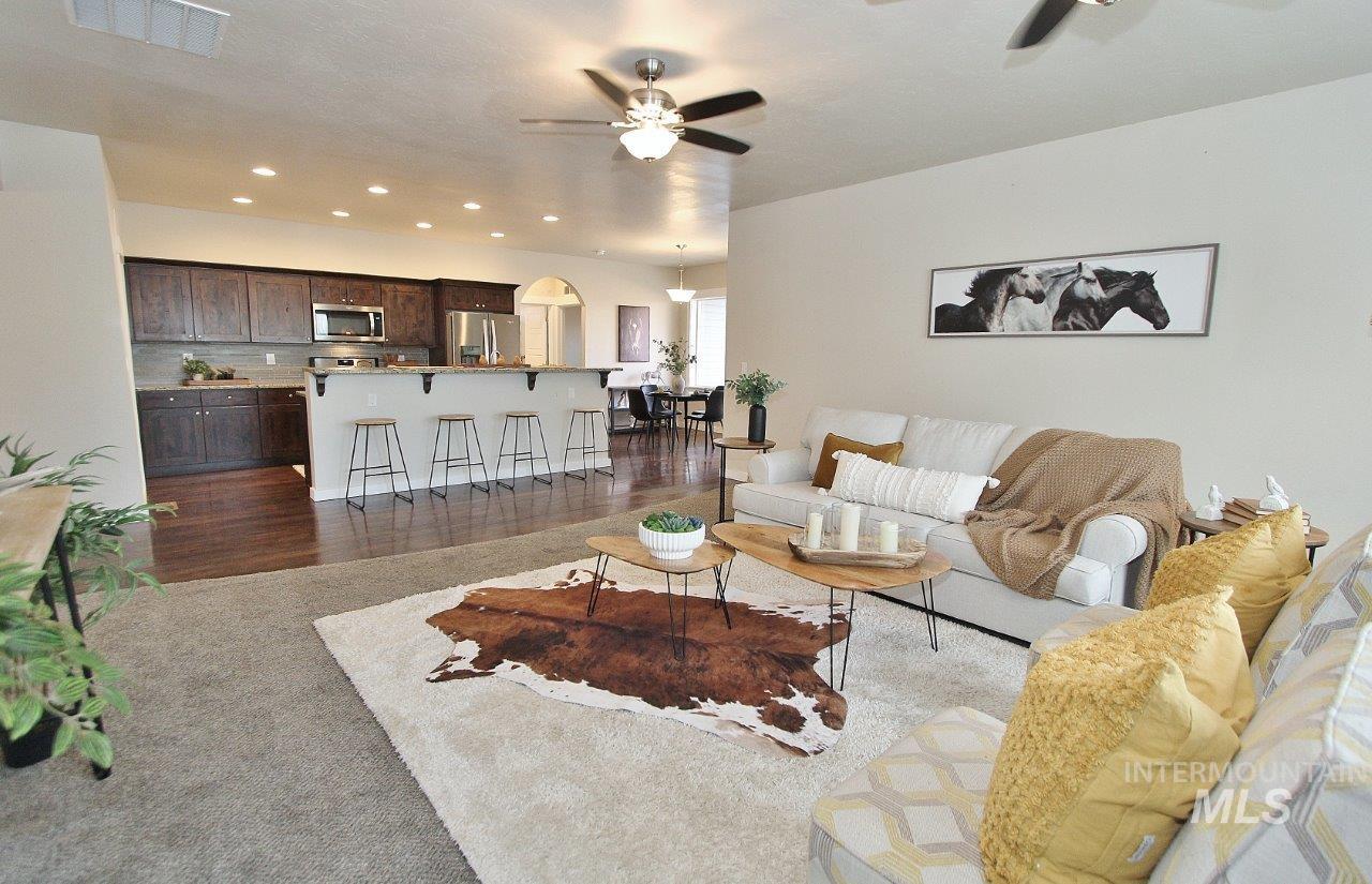 Living room with ceiling fan, dark wood finished floors, and recessed lighting