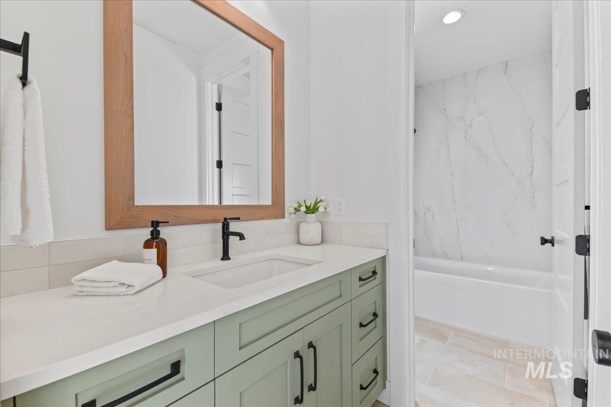 Bathroom with vanity, bathing tub / shower combination, and recessed lighting