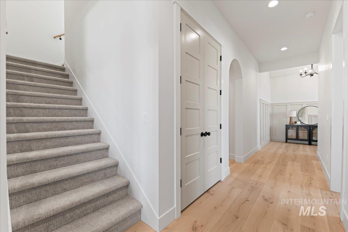 Staircase with wood finished floors, recessed lighting, and arched walkways