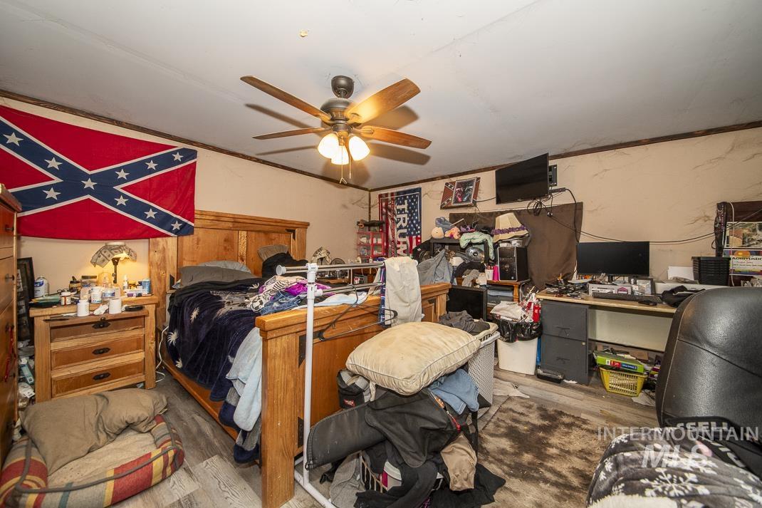 Bedroom featuring wood finished floors, a desk, and ceiling fan