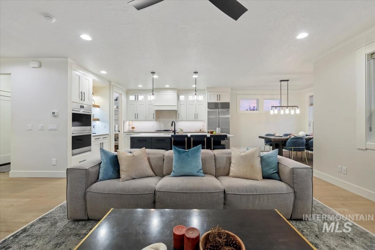 Living room featuring light wood finished floors, recessed lighting, and ceiling fan
