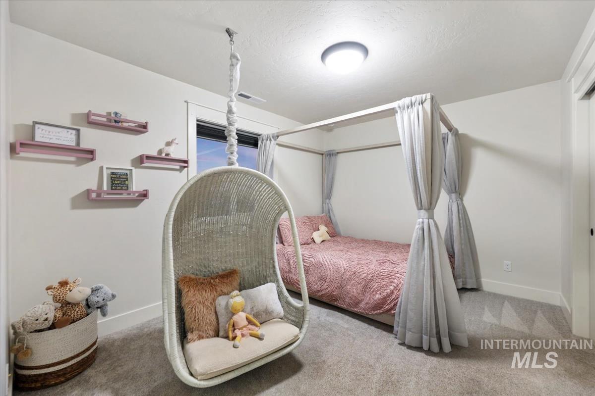 Carpeted bedroom with a textured ceiling and baseboards