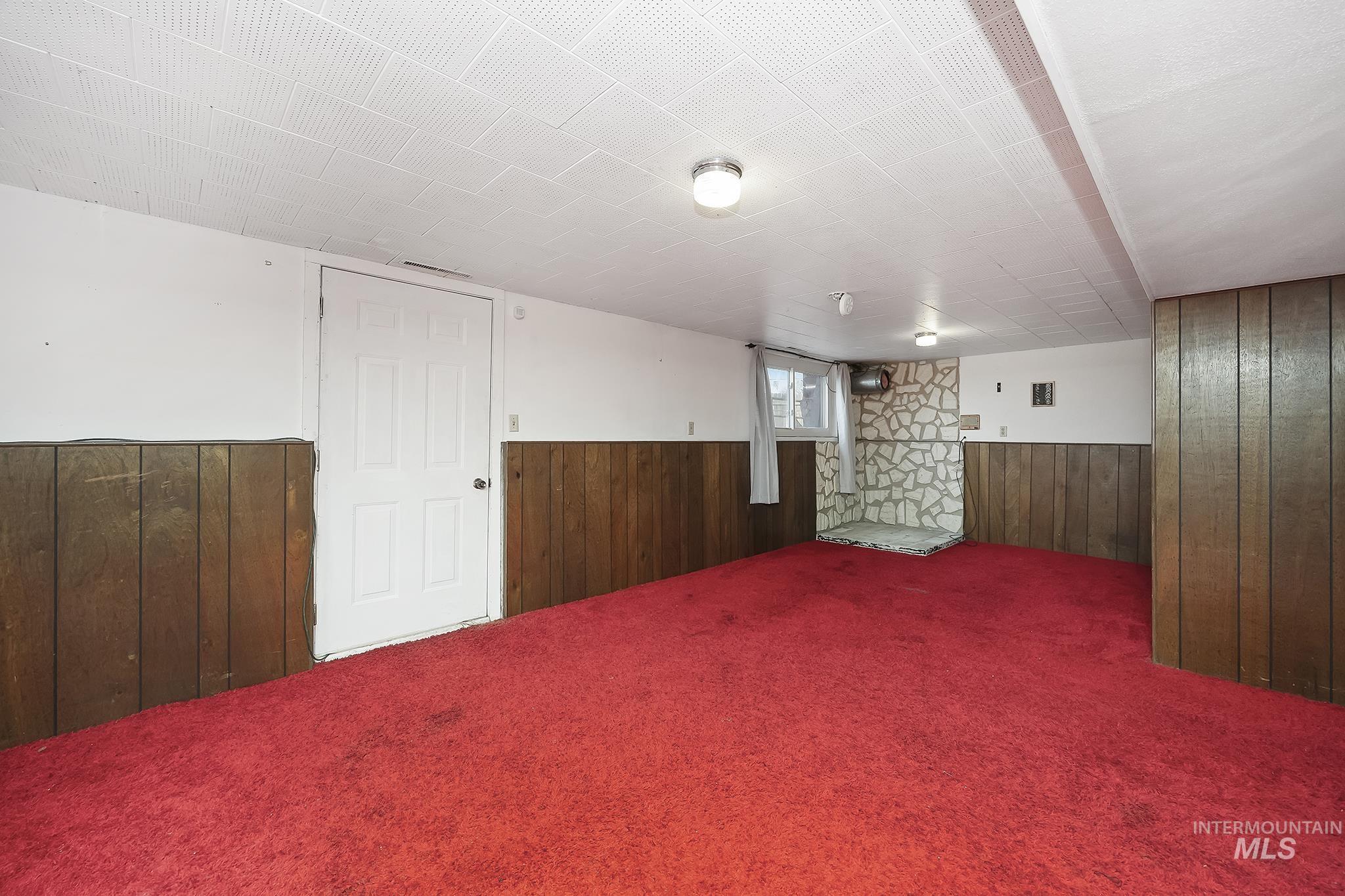 Below grade area with wood walls, carpet, and wainscoting