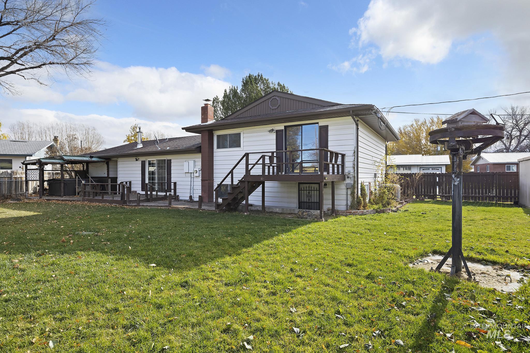 Back of property with a deck, a chimney, and stairs