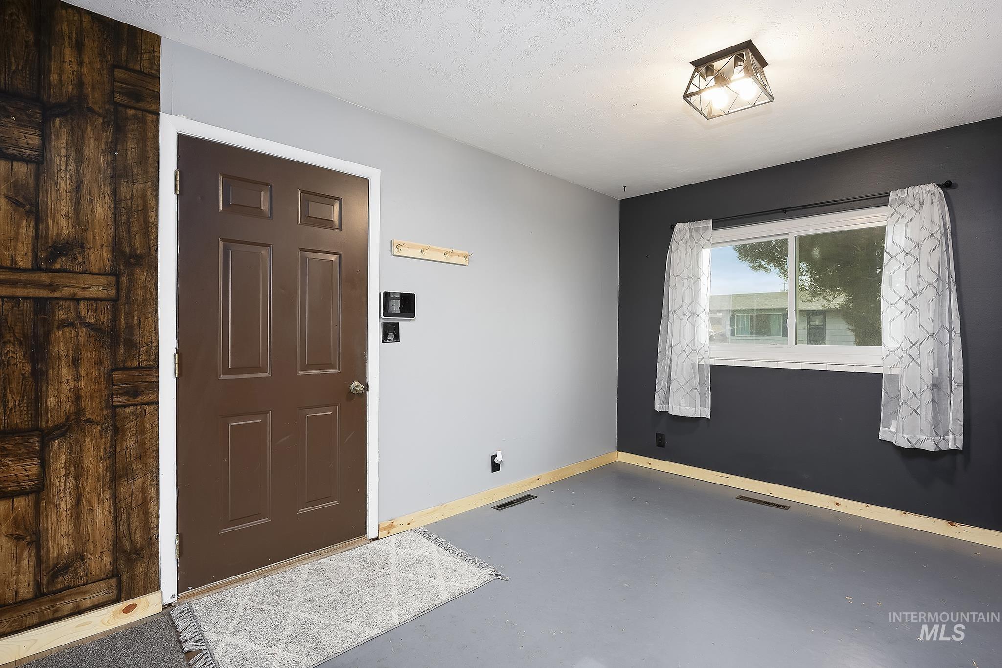 Foyer entrance with finished concrete floors and a textured ceiling