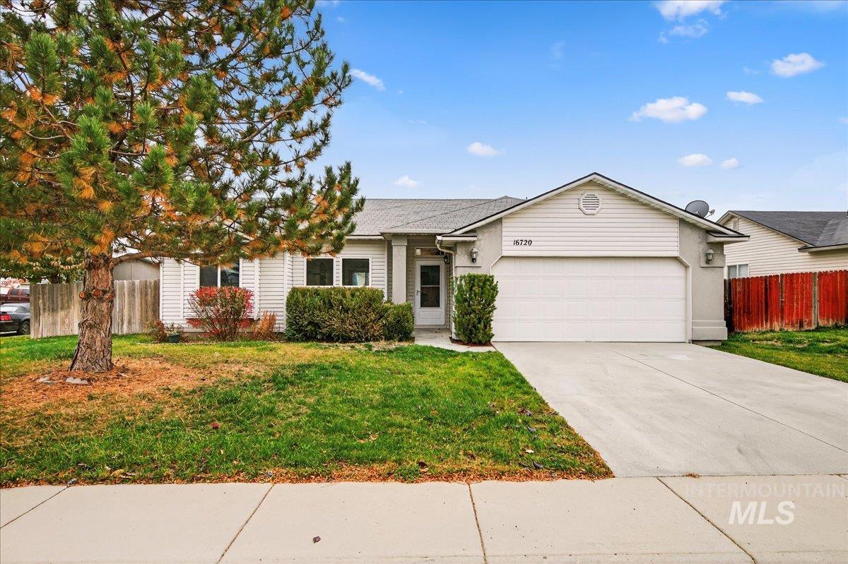 Ranch-style house featuring driveway, an attached garage, and roof with shingles