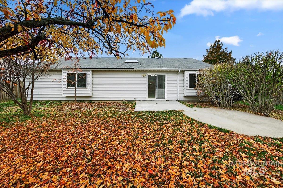 Rear view of house featuring a patio and roof with shingles