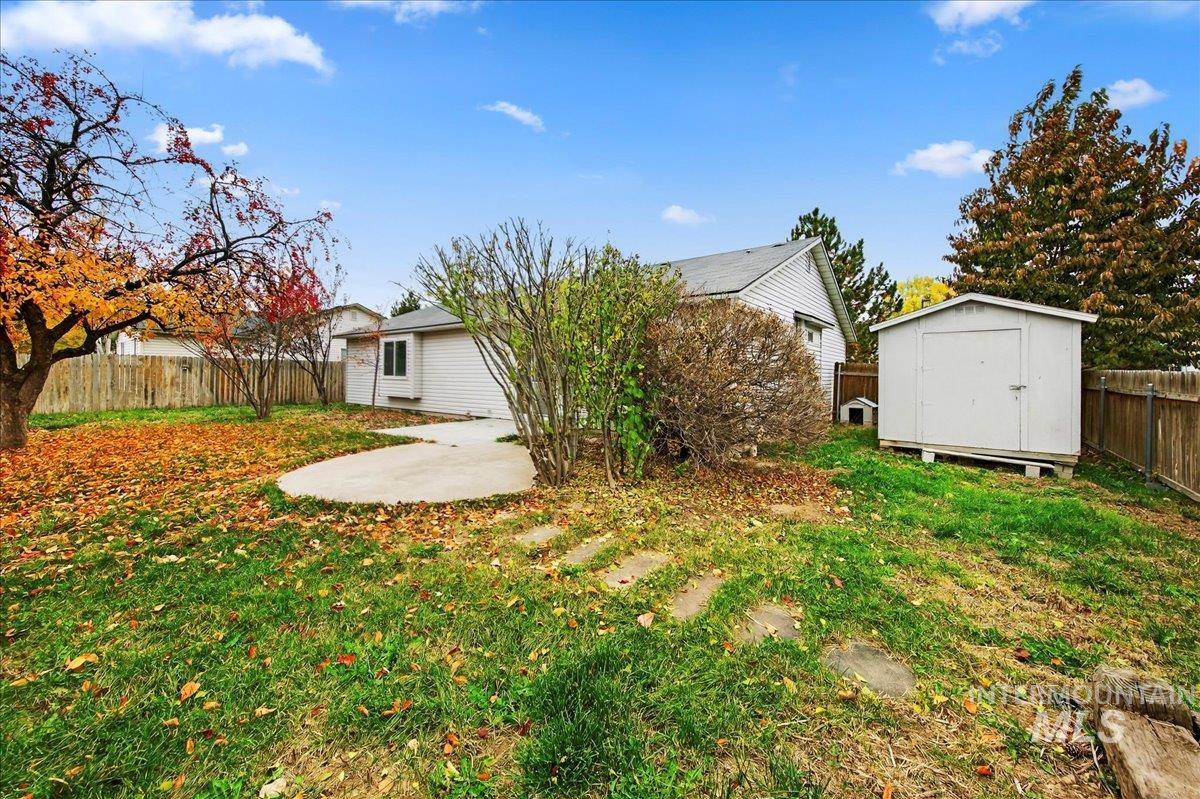 Back of house with a fenced backyard, a patio, and a shed