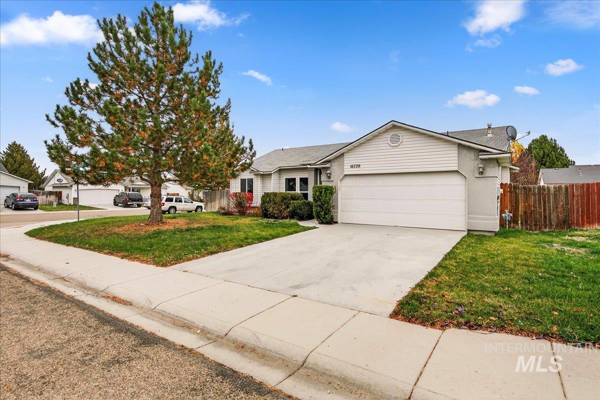 Ranch-style home featuring concrete driveway and an attached garage