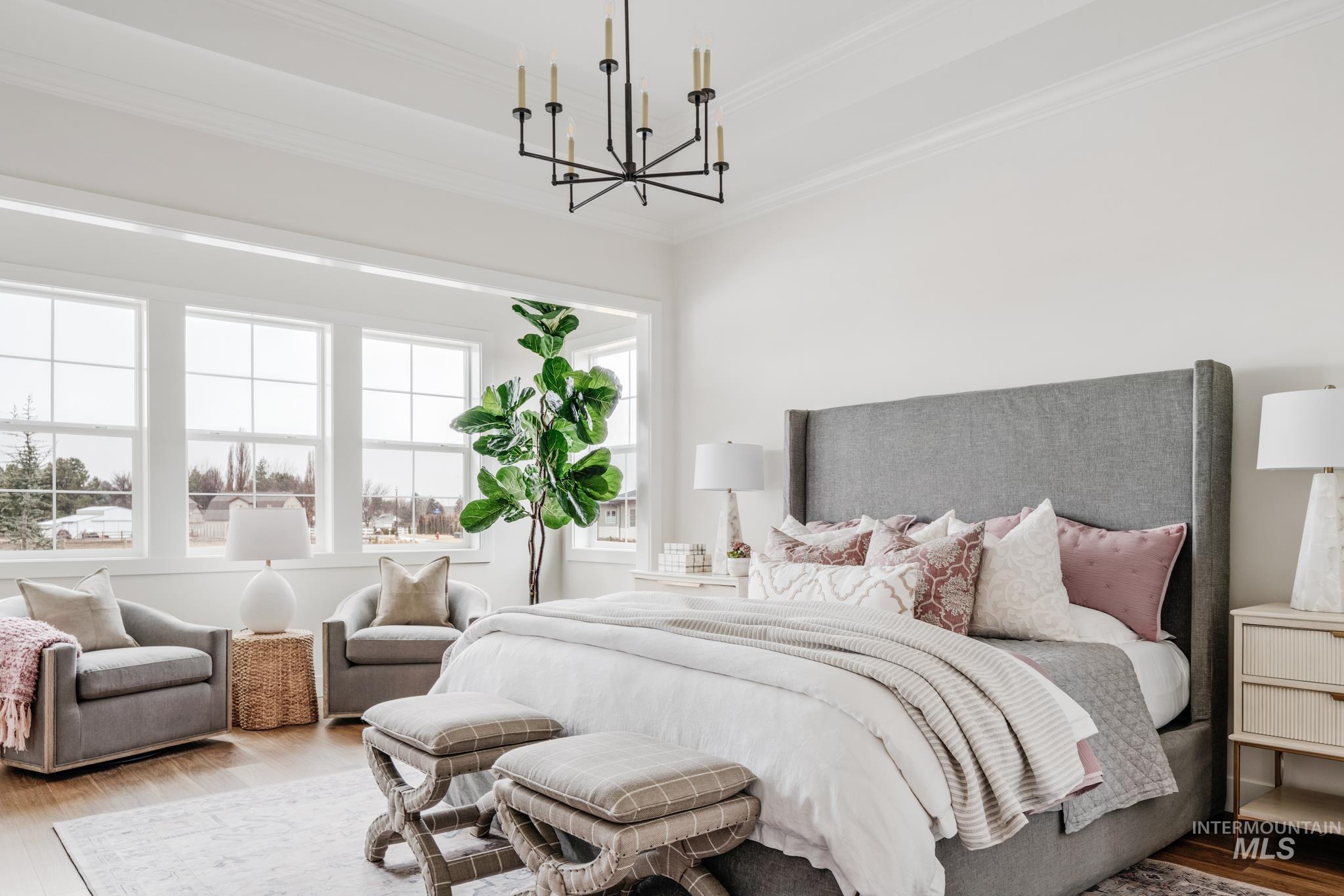 Bedroom featuring wood finished floors, ornamental molding, and a chandelier