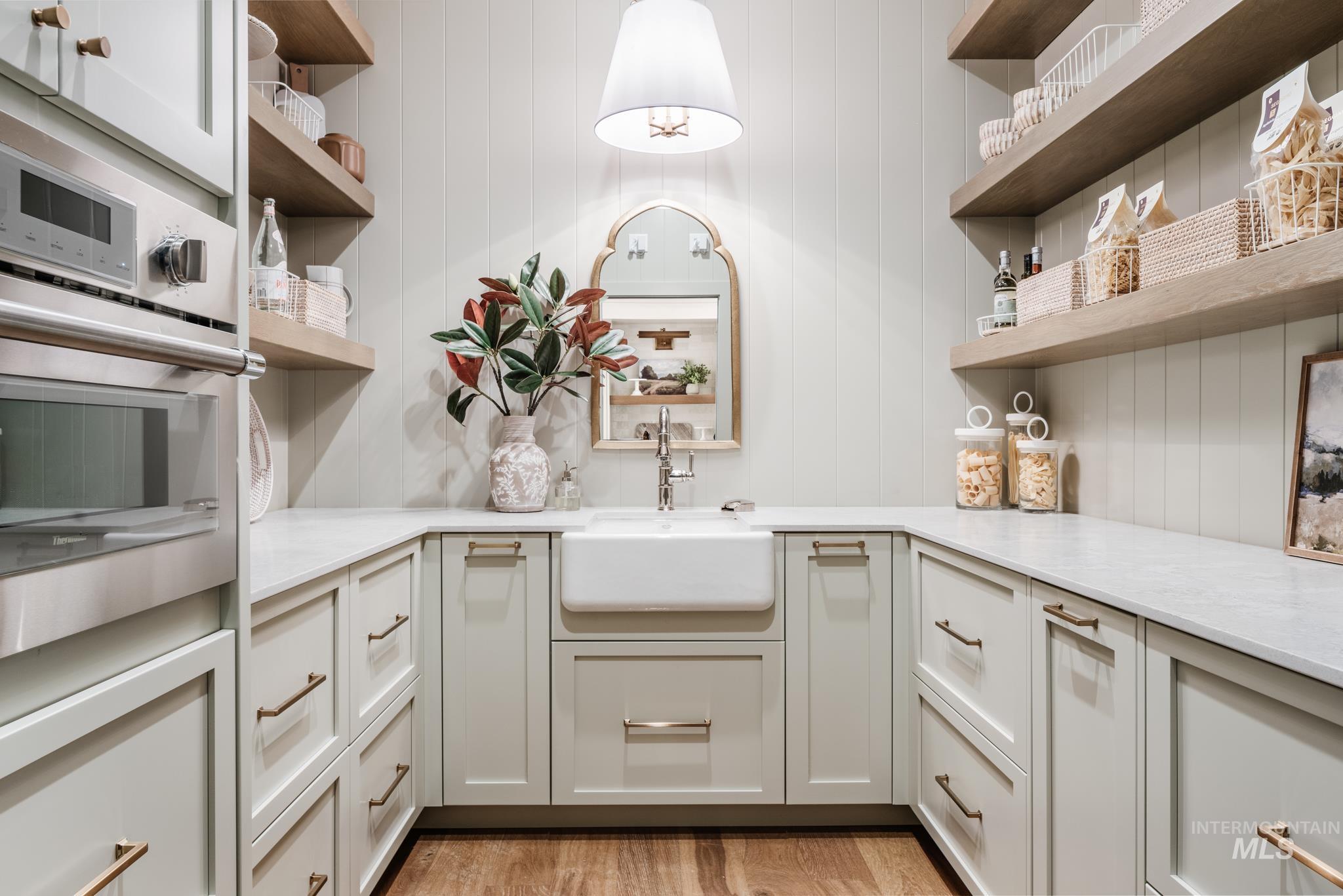 Kitchen featuring open shelves, oven, light stone countertops, and light wood-type flooring