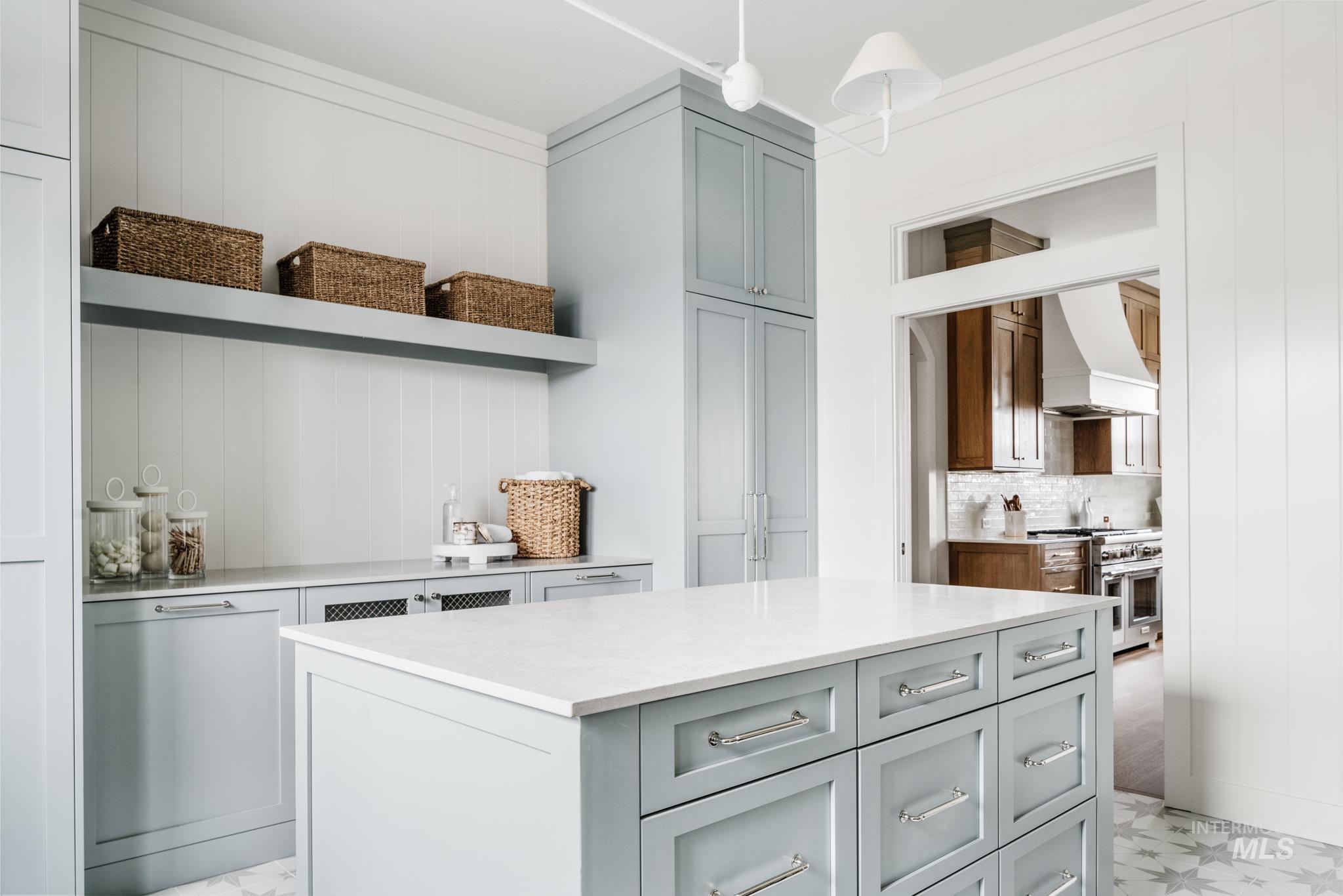 Kitchen with open shelves, premium range hood, range with two ovens, and gray cabinets