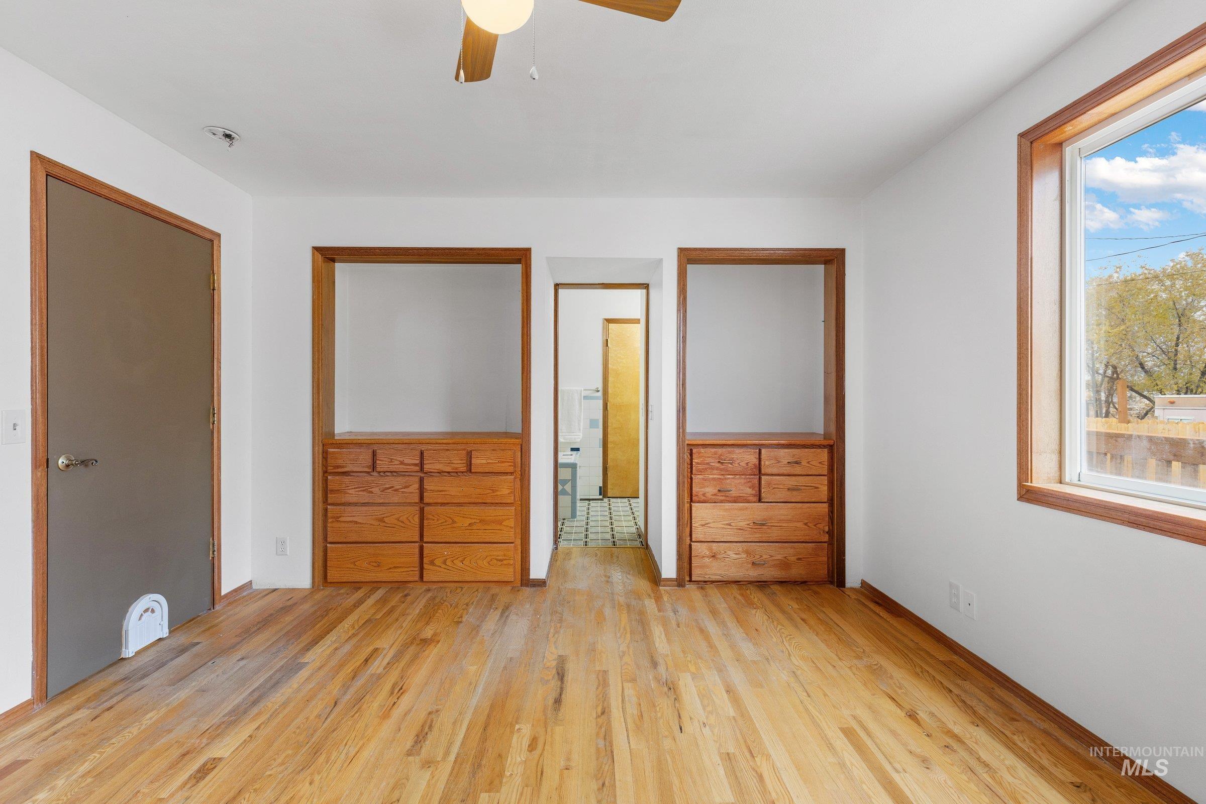 Unfurnished bedroom with wood finished floors, ceiling fan, and connected bathroom