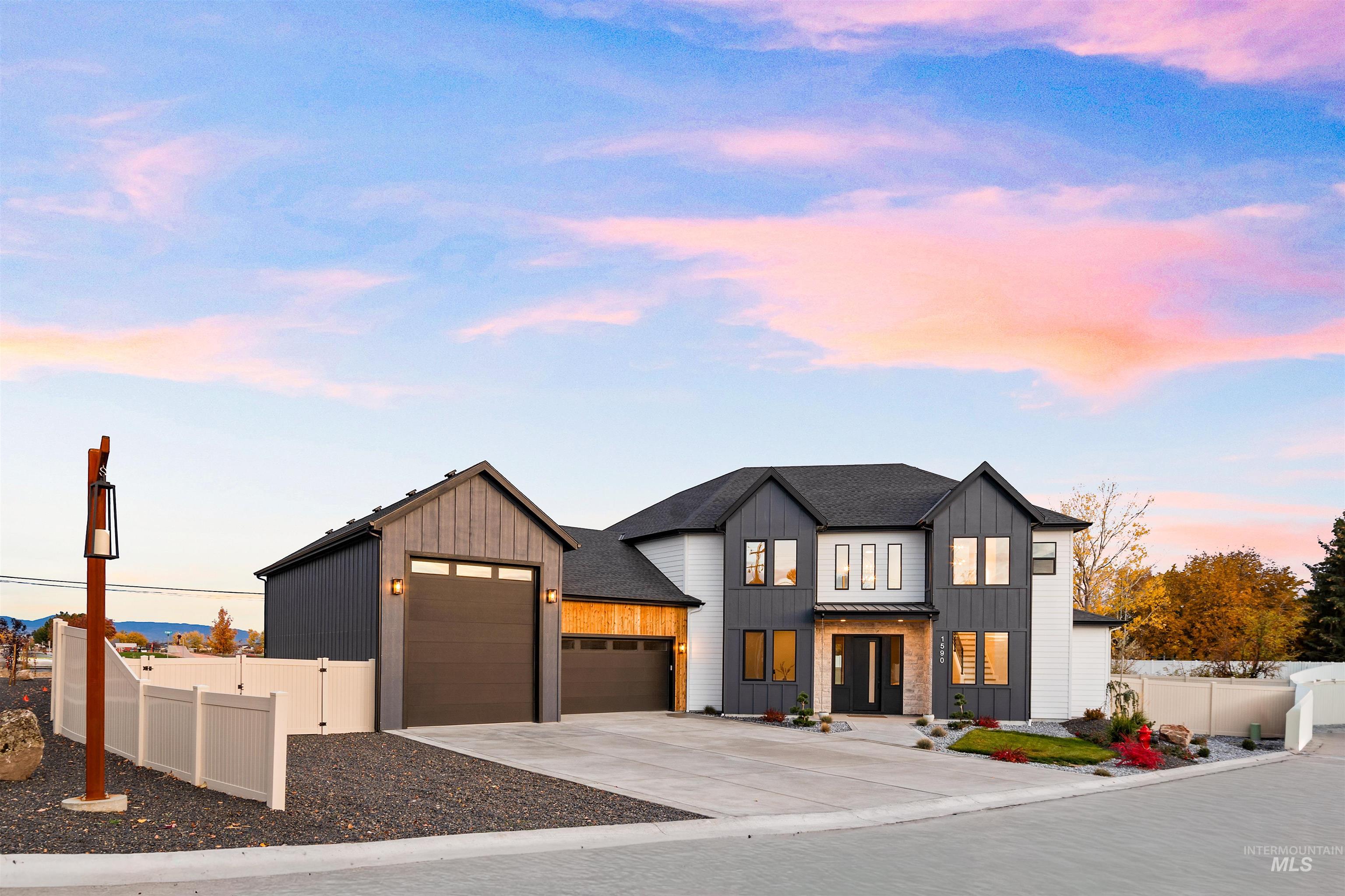 Modern farmhouse style home featuring board and batten siding, driveway, a garage, and a shingled roof