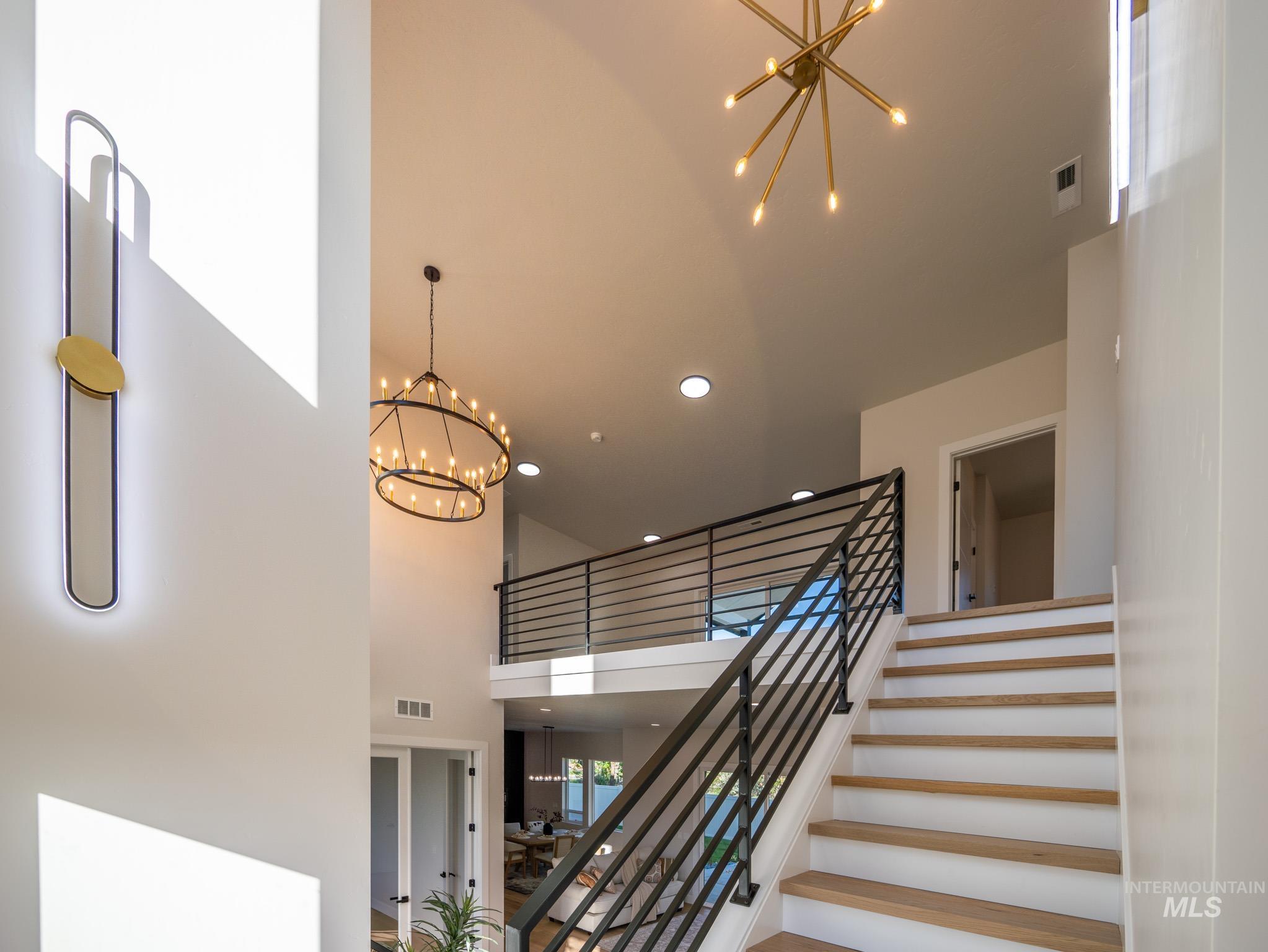 Stairs featuring a chandelier, recessed lighting, and a towering ceiling