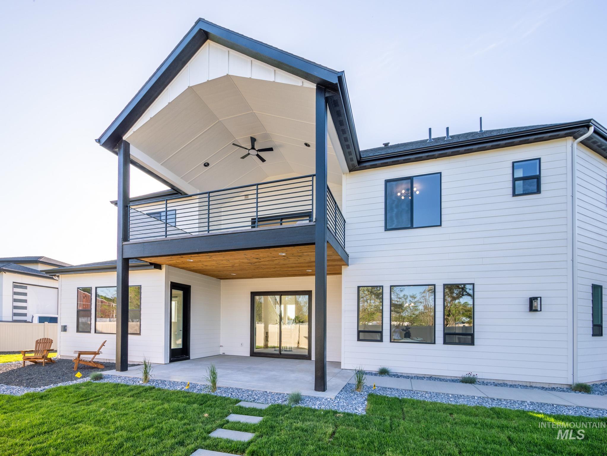 Back of house with a patio area, a yard, and a ceiling fan