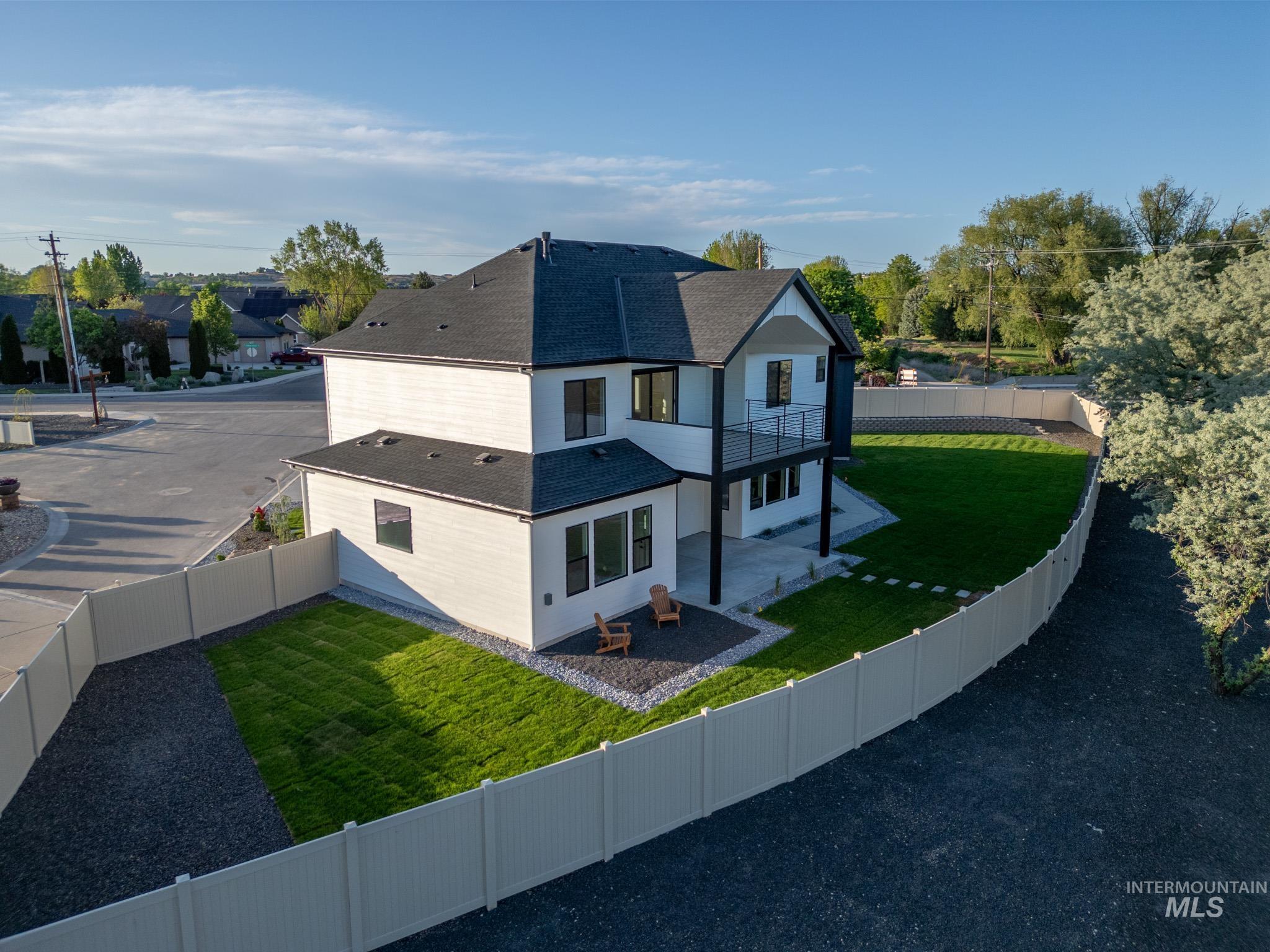 Back of property with roof with shingles, a fenced backyard, a patio area, and a balcony